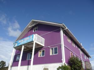 ein violettes Gebäude mit Balkon darüber in der Unterkunft Hostal Santa Fe in Castro
