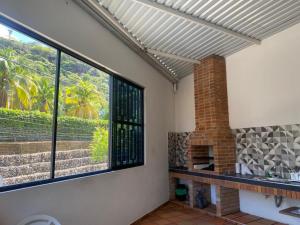 a living room with windows and a brick fireplace at Casa Hawai in Melgar