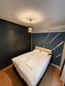 1 dormitorio con 1 cama grande y pared azul en Mükemmel Deniz Manzaralı Lüks, en Estambul