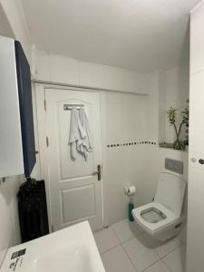 a white bathroom with a toilet and a sink at Mükemmel Deniz Manzaralı Lüks in Istanbul