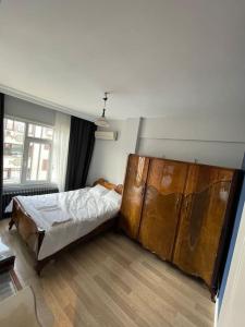 1 dormitorio con 1 cama y un gran armario de madera en Mükemmel Deniz Manzaralı Lüks, en Estambul