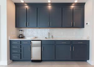 eine Küche mit schwarzen Schränken und einem Kühlschrank aus Edelstahl in der Unterkunft Phoenix Gulf Tower 1004 condo in Gulf Shores