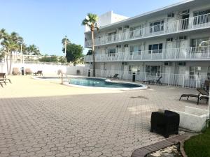 a building with a swimming pool in front of a building at Seaside serenity studio in Pompano Beach