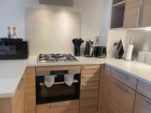 a kitchen with a stove with towels hanging from it at WATCH CHANGING OF THE GUARD AND WALK TO THE CASTLE! 2 Bedroom Apartment in Windsor
