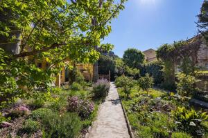 een tuin met veel bloemen en planten bij La Halte Provençale vaste gîte T1 avec jardin entre mer et collines in Roquevaire