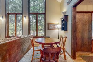 a dining room with a table and chairs and windows at Kinnikinnick in Glen Arbor