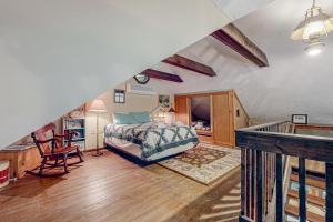 a attic bedroom with a bed and a staircase at Kinnikinnick in Glen Arbor