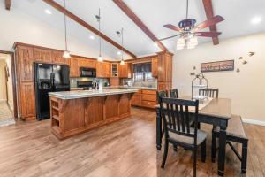 大贝尔城Moose Tracks Lodge - Forest and mountain views! Smart TV with streaming app and Game Room!的厨房配有木制橱柜和桌椅