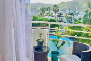 a balcony with potted plants and a view of a city at Appartement piscine et plage privée ! in Marigot