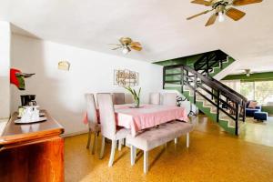 a dining room with a table and chairs and a staircase at Casa Verde El Golf in Barranquilla