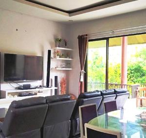 a living room with black leather chairs and a television at Vimala Hills FARLA Villa - 3BR in Gadok 1