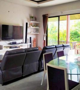 a living room with a couch and a glass table at Vimala Hills FARLA Villa - 3BR in Gadok 1