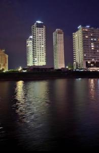 um horizonte da cidade à noite com um corpo de água em Amarras Center em Santa Fé