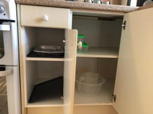 a kitchen cabinet with the door open to a kitchenventory at The Burnham House in Bath