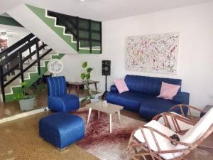 a living room with a blue couch and chairs at Casa Verde El Golf in Barranquilla