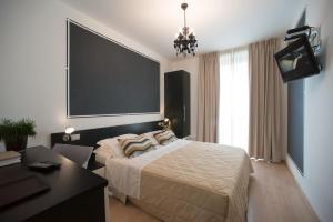 a bedroom with a bed and a flat screen tv at Berghotel in Bergamo