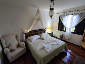 a bedroom with a bed and a chair with a bow on it at Casa Ortmann in Canela