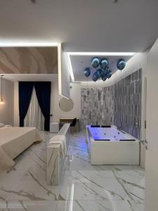 REDAMARE SUITE في لاغو باتريا: غرفة في الفندق مع حوض استحمام وغرفة نوم
