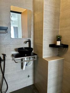 a bathroom with a sink and a mirror at Modern Stylish Apartment (Seaview) near KTCC Mall. in Kuala Terengganu