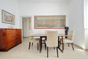 un comedor con mesa, sillas y una pintura en Vittorio Emanuele, en Roma