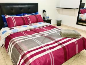 a bedroom with a large bed with a pink and purple comforter at Dorado Airport rooms & apartments in Bogotá