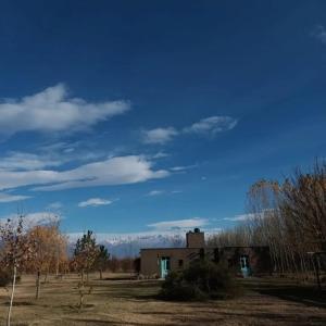 una vecchia casa in un campo con un cielo blu di Finca La Clementina a Tunuyán