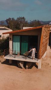 a woman standing on a porch of a house at Paraje Hotel de Campo in Ensenada