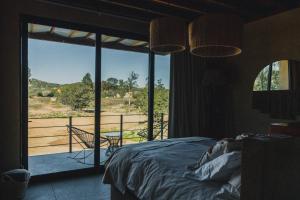 a bedroom with a bed and a balcony with a view at Paraje Hotel de Campo in Ensenada