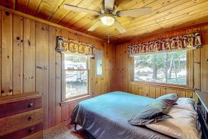 a bedroom with a bed and a ceiling fan at The Cabin on the Lake in Worley