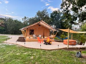 a small tent with a hammock in a yard at Tropical glamping with hot tub in Cleveland