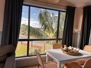 a living room with a table and a large window at South Coast Retreat in Greenwell Point