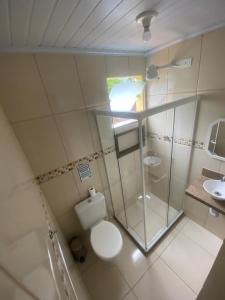 a bathroom with a toilet and a glass shower at Descanso do Jordão in Abraão