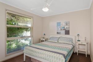 a white bedroom with a bed and two windows at 45 Norman Drive in Cowes