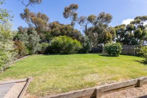 a large grassy yard with trees and a fence at 45 Norman Drive in Cowes