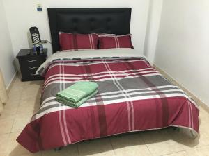 波哥大的住宿－Dorado Airport rooms & apartments，一张带红白条纹床罩的床