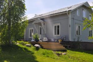 a gray house with a wooden deck in the yard at Villa Fridhem, Härnösand in Härnösand