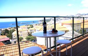 a table with a bottle of wine on a balcony at Carvalhal Old Town in Funchal