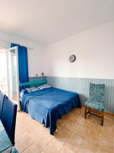 um quarto com uma cama azul e uma cadeira em Apartamento en Torre Valentina con vista al mar em Calonge