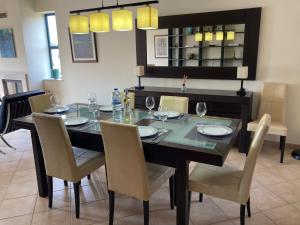 a dining room with a table and chairs with wine glasses at Casa dos Salgados in Albufeira