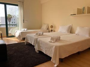 a bedroom with two beds with towels on them at Casa dos Salgados in Albufeira