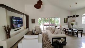 een woonkamer met een witte bank en een tafel bij Luxury 4-Bedroom Villa with Heated Pool in Residencial Casa Linda in Sosúa