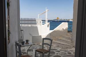 a table and two chairs and a table and some water at Portes View House in Parikia