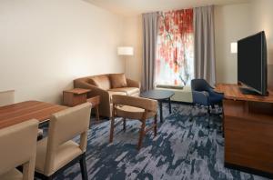 uma sala de estar com um sofá, uma mesa e uma televisão em Fairfield Inn & Suites by Marriott Orlando International Drive/Convention Center em Orlando
