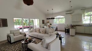 een woonkamer met witte banken en een keuken bij Luxury 4-Bedroom Villa with Heated Pool in Residencial Casa Linda in Sosúa
