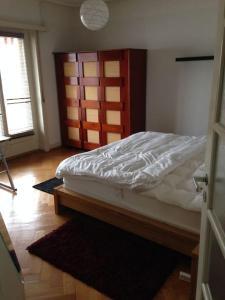 1 dormitorio con cama y cabecero de madera en Appartement de 3 chambres à coucher, en Lausana
