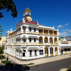 un edificio bianco con una torre dell'orologio sopra di Criterion Hotel-Motel Rockhampton a Rockhampton
