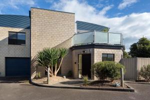 una casa de ladrillo con un balcón de cristal encima en Beachside Retreat Cowes, en Cowes