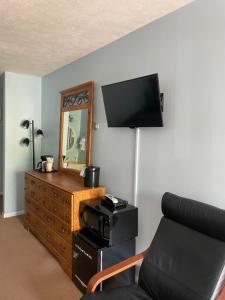 a living room with a tv and a couch and a dresser at M22 Inn Glen Arbor in Glen Arbor