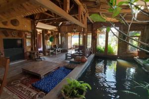 a house with a swimming pool and a living room at Villa Cetok Syariah - Nuansa Pedesaan in Simpen