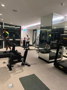 a gym with people exercising on treadmills and ellipticals at Prestige Hyde Park Studio Apartment in Sydney